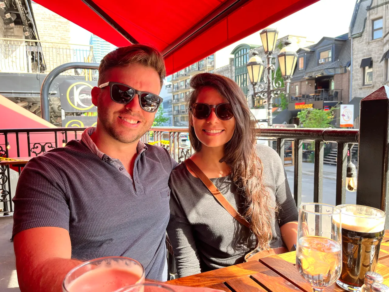 Patrick and his wife smiling on a sunny restaurant terrace in Montreal.